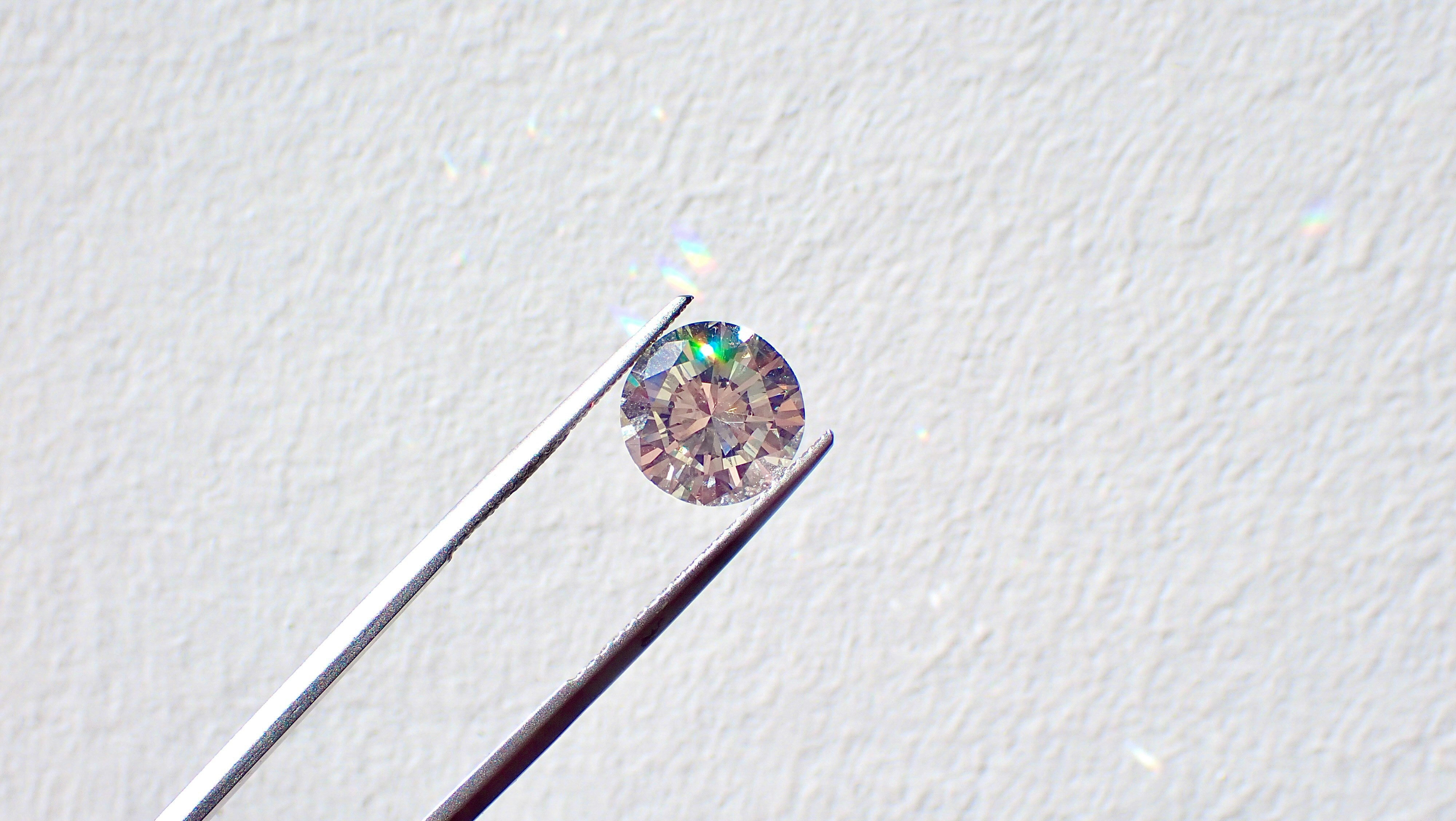 round diamond in tweezers